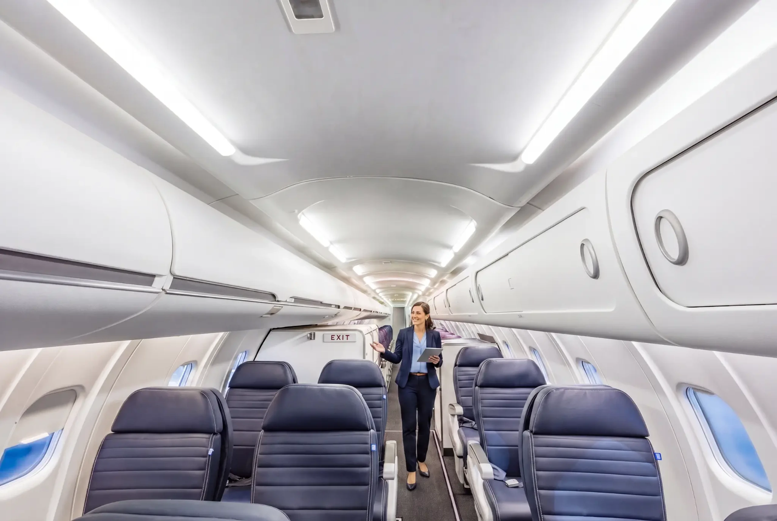 Aviation professional walking through a completed commercial aircraft cabin interior, representing GAL Aerospace certified cabin modification and retrofit programs for commercial operators